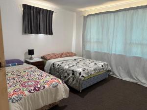 a room with two beds and a window at Private Rooms at Bayfair in Tauranga