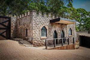 a brick building with a gate and a fence at BIG4 Kryal Castle Holiday Park Ballarat in Ballarat