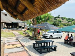 a picnic table with an umbrella next to a car at Siyaya Palace in Jozini
