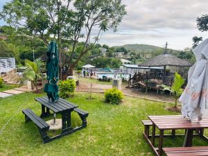 two picnic tables with an umbrella on the grass at Siyaya Palace in Jozini