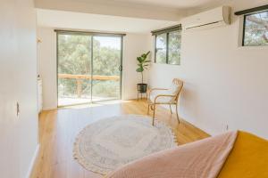 a living room with a chair and a rug at Franklin's Place in Belmont