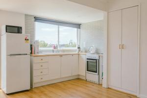 a kitchen with a white refrigerator and a window at Franklin's Place in Belmont +9 photos