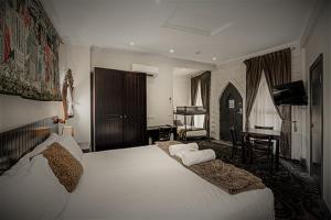 a bedroom with a large white bed and a desk at BIG4 Kryal Castle Holiday Park Ballarat in Ballarat +116 photos
