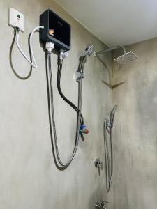 a shower in a bathroom with a soap dispenser at Sigiriya Carpenter Cottage in Sigiriya