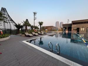 a large swimming pool with lounge chairs in a building at Măng Homestay in Kim Quan