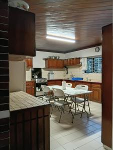 a kitchen with a table and chairs in it at Muaitale House in Suva