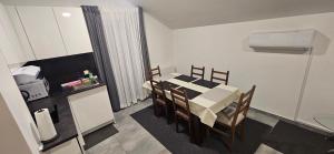 a dining room with a table and chairs and a kitchen at Apartman MAGDALENA in Sesvete +19 photos