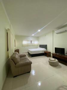 a living room with a couch and a bed at Puri Pangeran Hotel in Yogyakarta