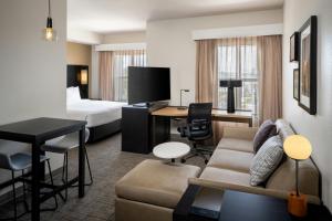 a hotel room with a couch and a bed at Residence Inn Melbourne in Melbourne