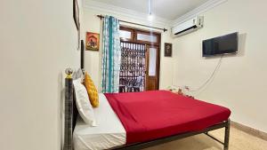 a room with a bed with a red blanket at Muffys Baga Apartment in Baga