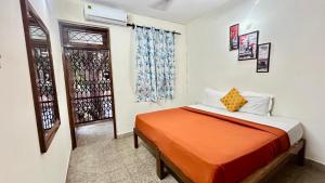 a bedroom with a bed with an orange blanket at Muffys Baga Apartment in Baga +21 photos