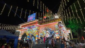 a group of people standing outside of a building with christmas lights at Muffys Baga Apartment in Baga