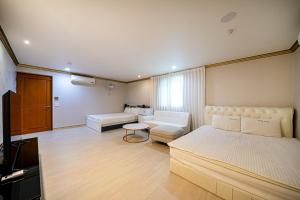 a bedroom with a bed and a couch and a television at 센스모텔 in Sasang-yŏk