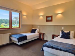 a hotel room with two beds and a window at Naseby Apartments in Naseby