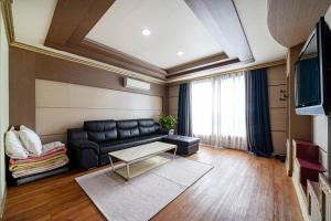 a living room with a black couch and a table at 센스모텔 in Sasang-yŏk