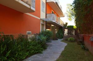 un bâtiment orange avec une passerelle devant lui dans l'établissement Motta Residence Hotel, à Motta SantʼAnastasia