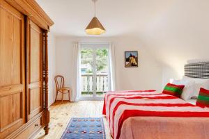 a white bedroom with a bed and a window at Zita Ferienhäuser - Ferienhaus Burgi in Neckargemünd