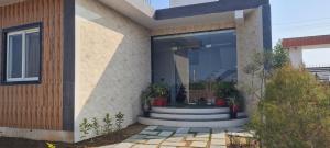 a house with a glass door with plants in it at AmarVandana Palace in Rādha Kund