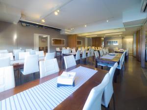 a dining room with white chairs and desks and tables at Hotelli & Ravintola Martinhovi in Raisio