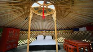 a room with a bed in a yurt at miniモンゴルキャンプ場 in Gujo