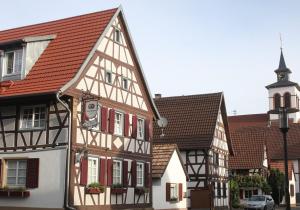 eine Gruppe von Gebäuden mit roten Dächern und eine Kirche in der Unterkunft Hotel Duwakschopp in Herxheim