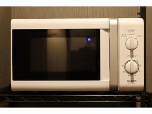 a white microwave oven sitting on top of a shelf at Smile Hotel Aomori in Aomori