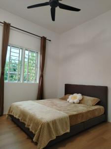 a bedroom with a bed with a ceiling fan at Risfeena Home in Sekinchan +3 photos