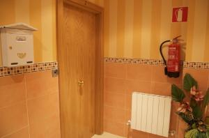 a bathroom with a door and a fire extinguisher at Pension Zorroza 1 in Bilbao