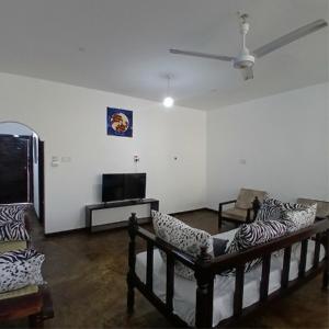 a living room with a couch and a tv at Tatia apartment in Malindi