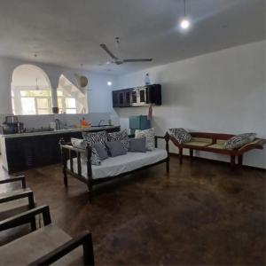 a living room with a couch and a kitchen at Tatia apartment in Malindi