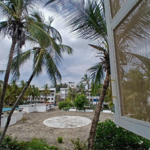 a view of a courtyard with palm trees and a building at Tatia apartment in Malindi
