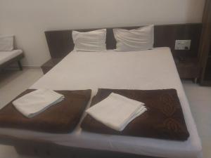 a large bed with two pillows on top of it at Hotel Jawahar Palace in Bhusāwal
