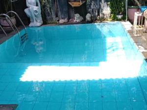a blue swimming pool with a blue tile floor at FM Homestay Banyuwangi in Banyuwangi