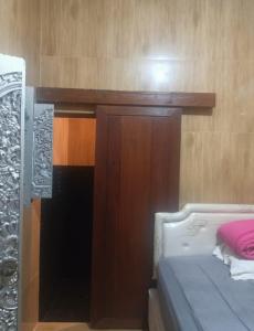 a bedroom with a bed and a wooden wall at FM Homestay Banyuwangi in Banyuwangi