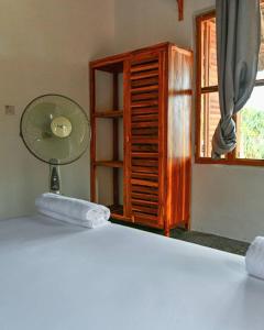 a room with a fan and a window at Amani Beach House, Ushongo in Pangani
