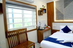 a bedroom with a bed and a window and a chair at Cloud9 Airport Hotel in Nedumbassery +64 photos