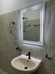 a bathroom with a sink and a window and a shower at Manthraa Holiday Apartment in Ratgama Hegoda +12 photos