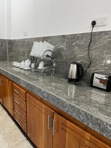 a kitchen with a counter top with cups and a toaster at Manthraa Holiday Apartment in Ratgama Hegoda