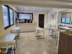a restaurant with tables and chairs and a counter at The Santo George Beach Resort in Amoudara Herakliou