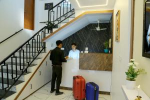 a man standing next to a woman at a counter at Cloud9 Airport Hotel in Nedumbassery