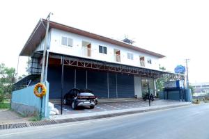a building with a car parked in front of it at Cloud9 Airport Hotel in Nedumbassery