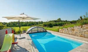 a swimming pool with an umbrella next to a patio at Ferienhof Broger FeWo Obstbäumle mit Pool in Neukirch