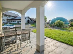 a patio with a table and chairs on a lawn at Ferienhof Broger FeWo Obstbäumle mit Pool in Neukirch