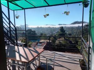 a balcony with a table and a view of the mountains at Cloudberry Inn Vibe in Nuwara Eliya
