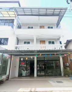 a white building with a restaurant in front of it at YP Hostel in Ban Nai Na