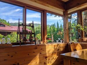 a room with a large window with a view of the mountains at ペンション木いちご PensionKiichigo in Zaō Onsen