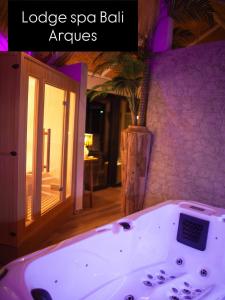 a bath tub with a clock in a room at Spa Bali in Arques