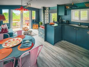 a kitchen with blue cabinets and a table and chairs at The Herdsman - Uk50615 in Sabden