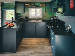 a kitchen with dark blue cabinets and a sink at The Herdsman - Uk50615 in Sabden