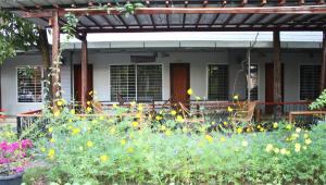 a garden with yellow flowers in front of a house at My Parents Guesthouse in Kampot +54 photos